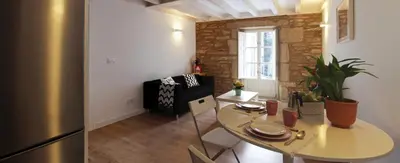 a kitchen and dining room with a table and a refrigerator at Puerta del Camino in Santiago de Compostela