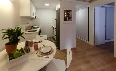 a kitchen and dining room with a white table and chairs at Puerta del Camino in Santiago de Compostela