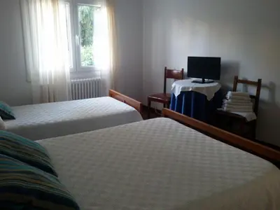 a hotel room with two beds and a television at Hostal Pumar in Santiago de Compostela