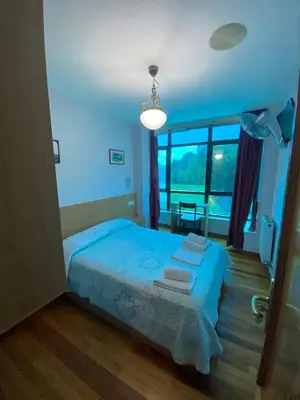 a bedroom with a blue bed and a large window at Hostal Pumar in Santiago de Compostela