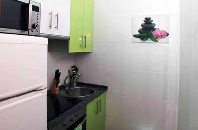 a small kitchen with a sink and a microwave at Albergue Los Caminantes 2 in Arzúa