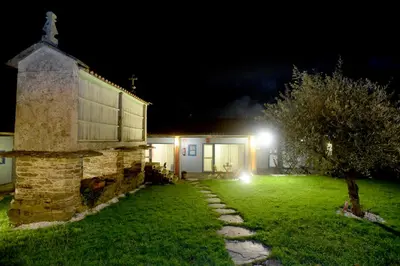 a church at night with a tree and a building at Casa de Amancio in Lavacolla