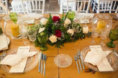 a wooden table with plates and a centerpiece of flowers at Casa de Amancio in Lavacolla