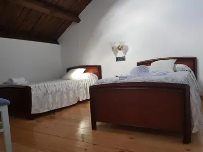 two beds in a room with white walls and wooden floors at Albergue Savior in Lourenzá