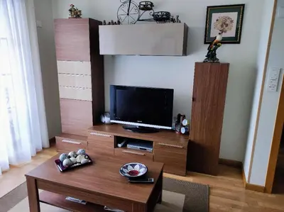 a living room with a tv and a table at Precioso Apartamento con Spa en Galicia / Playa Catedrales in Foz