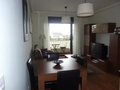a living room with a wooden table and a dining room at Precioso Apartamento con Spa en Galicia / Playa Catedrales in Foz