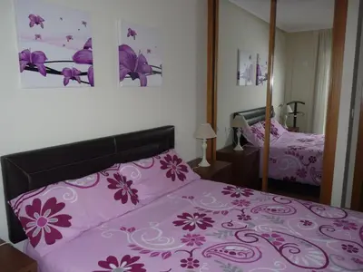 a bedroom with a pink bed and a mirror at Precioso Apartamento con Spa en Galicia / Playa Catedrales in Foz
