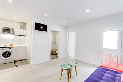 a living room with a couch and two stools at Santiago Center Rooms in Santiago de Compostela