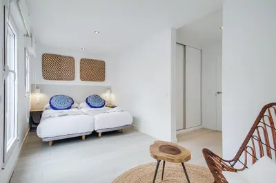 a bedroom with a bed with two blue and white pillows at Santiago Center Rooms in Santiago de Compostela
