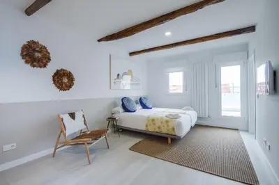 a bedroom with a bed and a chair at Santiago Center Rooms in Santiago de Compostela