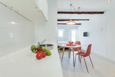 a kitchen and dining room with a table and vegetables on a counter at Santiago Center Rooms in Santiago de Compostela