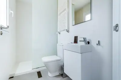 a white bathroom with a toilet and a mirror at Santiago Center Rooms in Santiago de Compostela