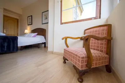 a room with a chair and a bed in a room at La Posada de La Casona de Sarria in Sarria