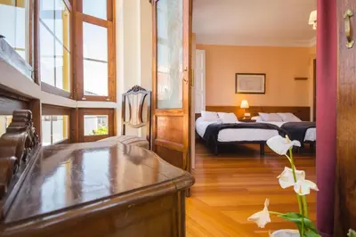 a hotel room with two beds and a bathroom at La Posada de La Casona de Sarria in Sarria