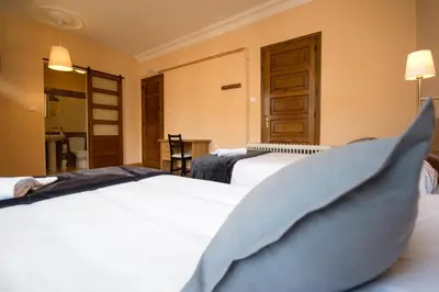 a hotel room with two beds in a room at La Posada de La Casona de Sarria in Sarria