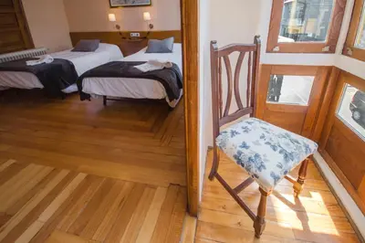 a room with two beds and a chair in it at La Posada de La Casona de Sarria in Sarria
