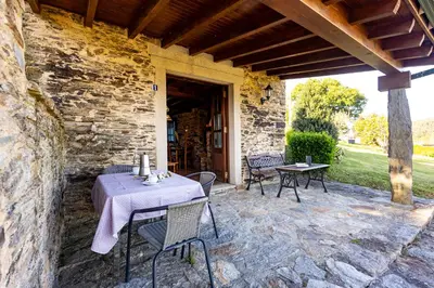 a table and chairs on a stone patio at Naturlar Casa do Cura in Beigondo
