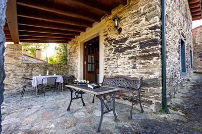 a patio with a table and chairs on a building at Naturlar Casa do Cura in Beigondo