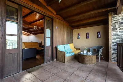 a screened in porch with a couch and a table at Naturlar Casa do Cura in Beigondo