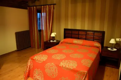 a bedroom with a orange bed and two night stands at Naturlar Casa Teillor in Moldes