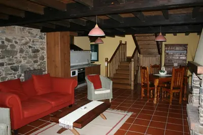 a living room with a red couch and a table at Naturlar Casa Teillor in Moldes