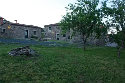 a stone house with a fire pit in the yard at Naturlar Casa Teillor in Moldes