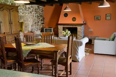 a dining room with a table and a fireplace at Naturlar Casa Teillor in Moldes
