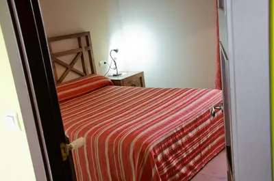 a bedroom with a bed with a red striped sheets at Naturlar Casa Teillor in Moldes