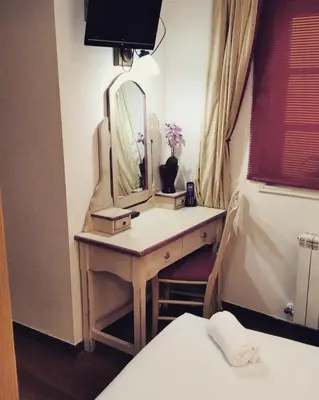 a bedroom with a dressing table with a mirror at Hotel Fonte de San Roque in Santiago de Compostela