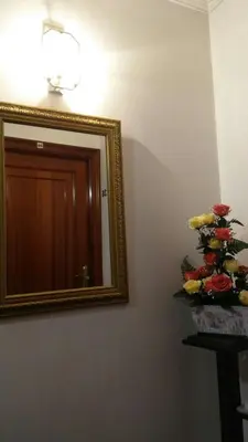 a mirror on a wall with a vase of flowers at Pensión Casa Frade in Arzúa