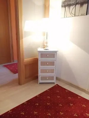 a bedroom with a dresser and a red rug at Pensión Casa Frade in Arzúa