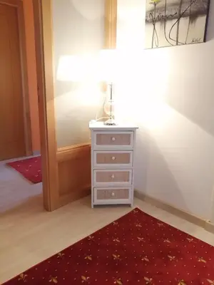 a room with a dresser and a red rug at Pensión Casa Frade in Arzúa