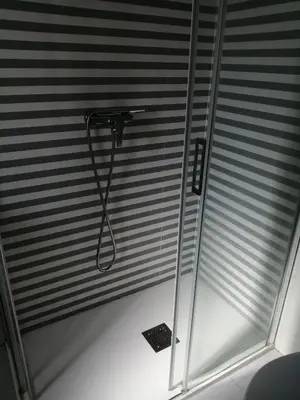 a room with a shower with blinds at Pensión Casa Frade in Arzúa