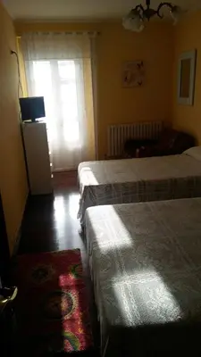 a bedroom with two beds and a window at Pensión Casa Frade in Arzúa