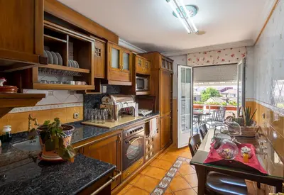 a kitchen with wooden cabinets and a counter top at El Descanso de Wendy in Astorga