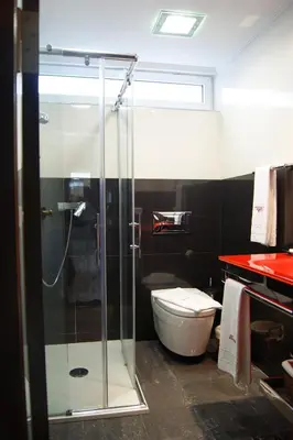 a bathroom with a toilet and a glass shower at El Descanso de Wendy in Astorga