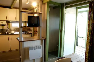 a kitchen with a microwave and a tv on a shelf at Camping As Cancelas in Santiago de Compostela