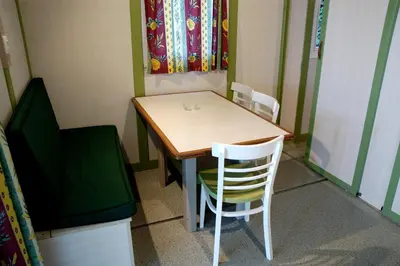 a table and chairs in a room with a television at Camping As Cancelas in Santiago de Compostela