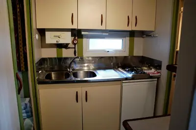a small kitchen with a sink and a microwave at Camping As Cancelas in Santiago de Compostela
