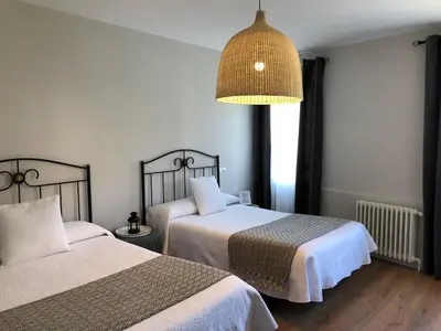 a hotel room with two beds and a lamp at Pensión Fernández in Vega de Valcarce