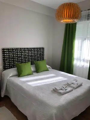a bedroom with a large bed with green pillows at Pensión Fernández in Vega de Valcarce