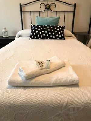 a white towel sitting on top of a bed at Pensión Fernández in Vega de Valcarce