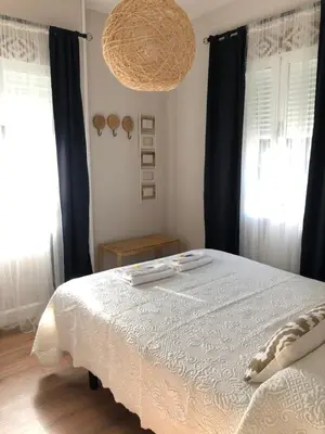 a bedroom with a large bed with blue curtains at Pensión Fernández in Vega de Valcarce