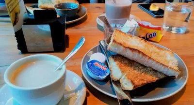a plate with a sandwich and a cup of coffee at Pensión Garcia in Tríacastela