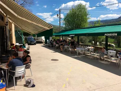 a group of people sitting at tables outside a restaurant at Pensión Garcia in Tríacastela