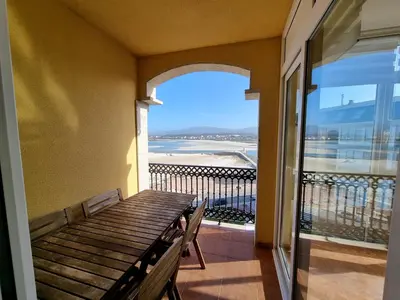 a balcony with a bench and a view of the beach at Dúplex en 1ª línea de playa in Foz