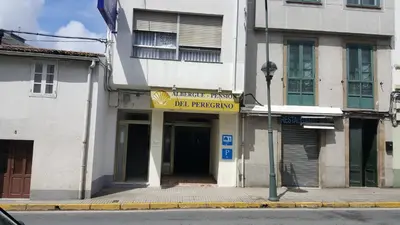 a building with a yellow sign on the front of it at Del Peregrino in Arzúa