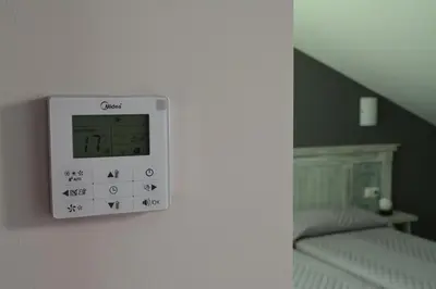 a clock on a wall next to a bed at Hotel Mica in Palas de Rei