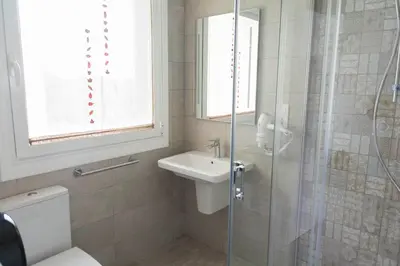 a bathroom with a toilet and a sink and a shower at Hotel Mica in Palas de Rei