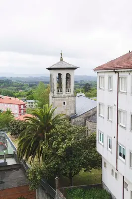 an old building with a bell tower in a city at Hotel Mica in Palas de Rei